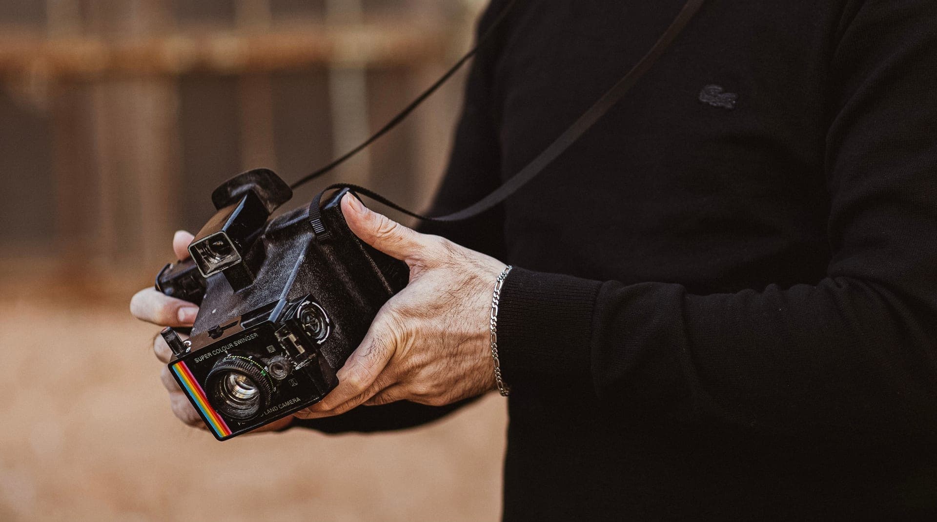 Hands holding a camera, deciding what to buy