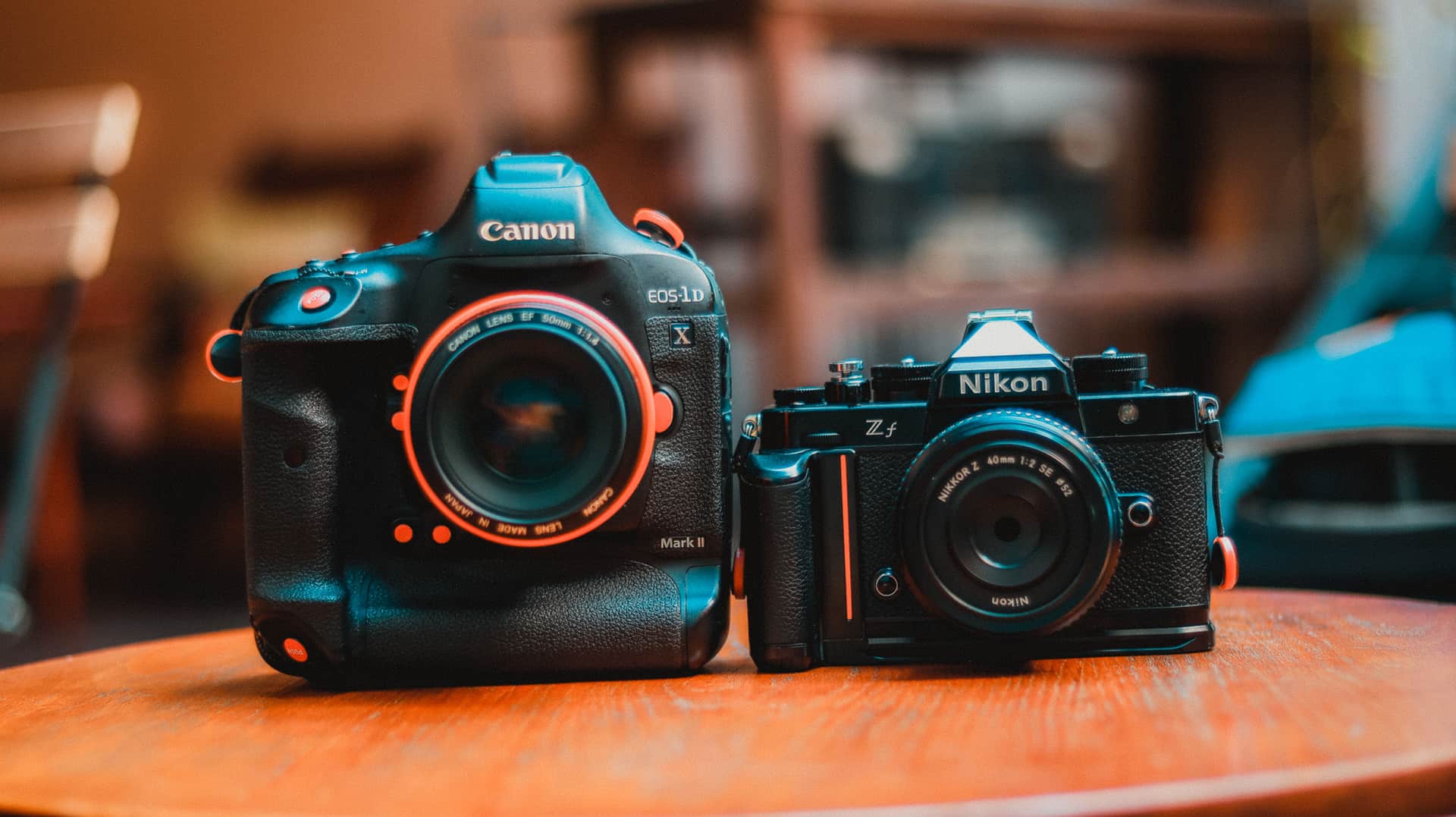 Two cameras side by side on a wooden surface